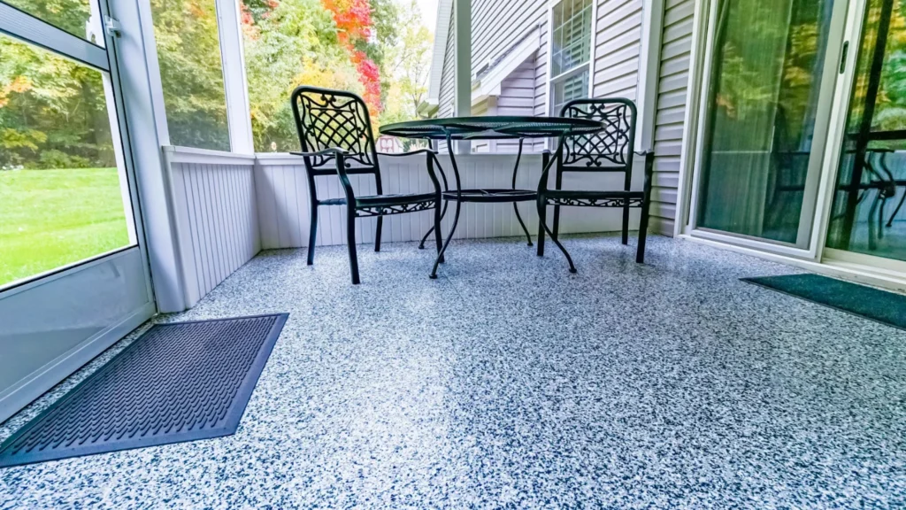Epoxy flake flooring in a sunroom with black chairs.