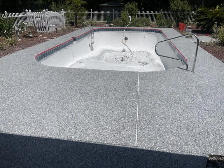 Gray flake pool deck coating around an in-ground pool