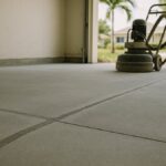 Garage concrete floor diamond ground for a coating, with a long crack chased, filled and ground flush beside a saw-cut control joint